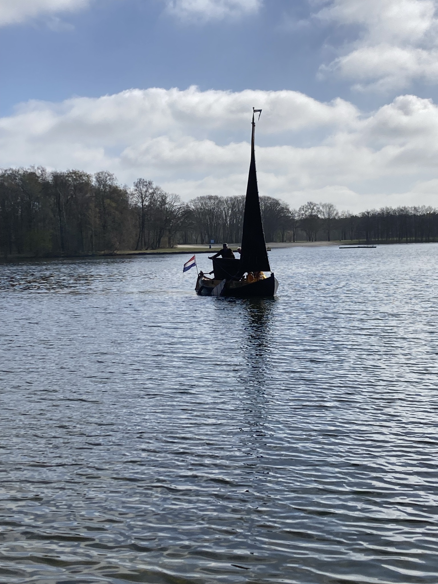Een boot met passagiers die langs de groene oevers van de Buurserbeek vaart.